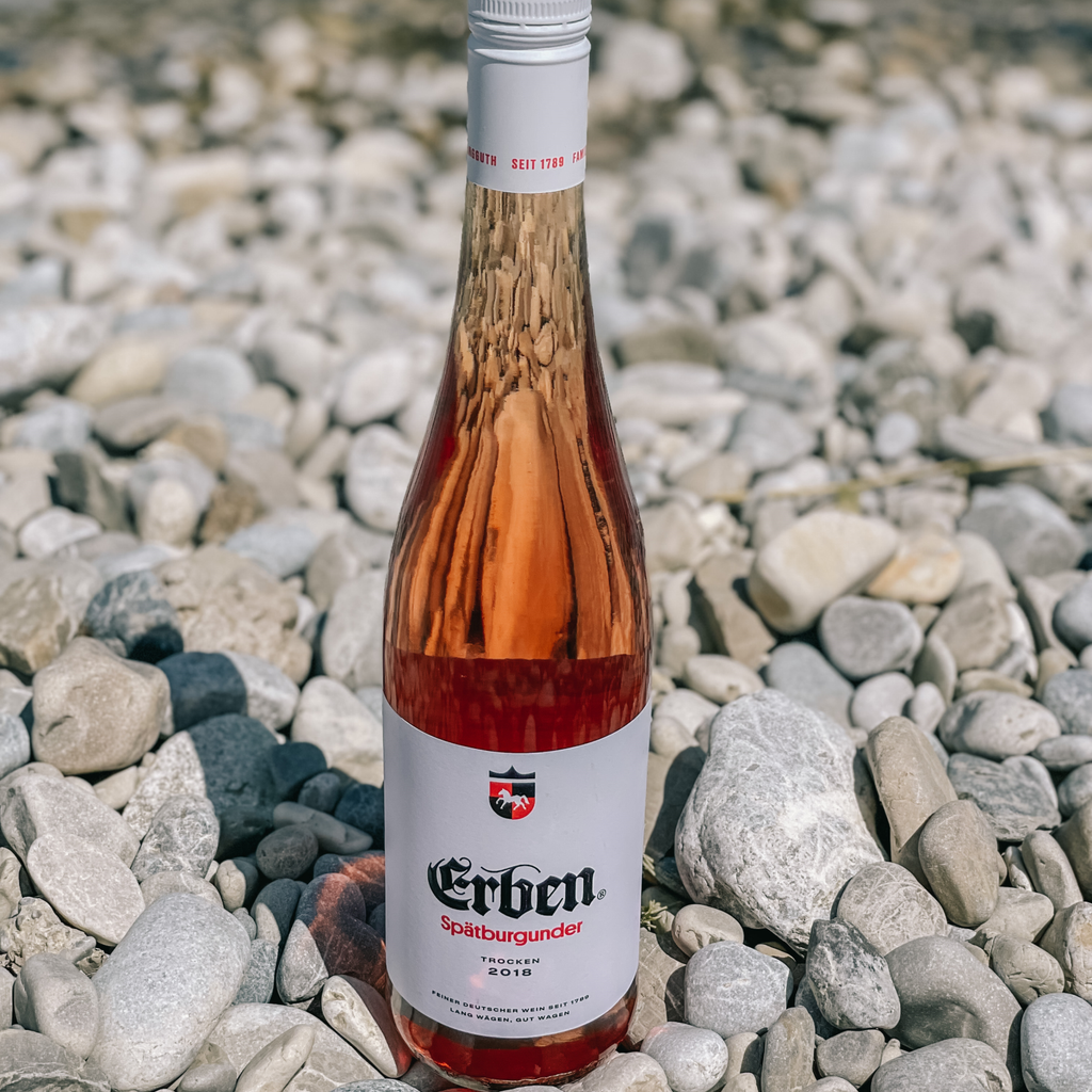 ERBEN Spätburgunder Rosé Trocken 0,75l - Roséwein - stehend in einem Meer aus Steinen 