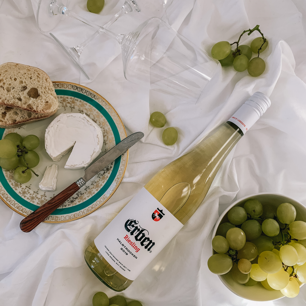 ERBEN Riesling Halbtrocken 0,75l - Weißwein - liegend neben einem Teller mit Käse und Trauben 